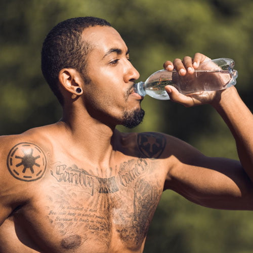 Sportswoman takes care of her tattoos by hydrating herself well